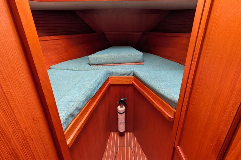 Firefly Yacht Photos Pics Cozy cabin interior of 1985 Siltala Nauticat 44 with blue cushions and wooden finish.