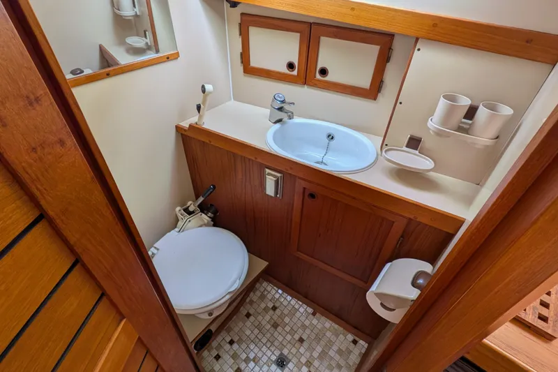 Firefly Yacht Photos Pics 1985 Siltala Nauticat 44 yacht bathroom with wooden cabinetry and compact design.