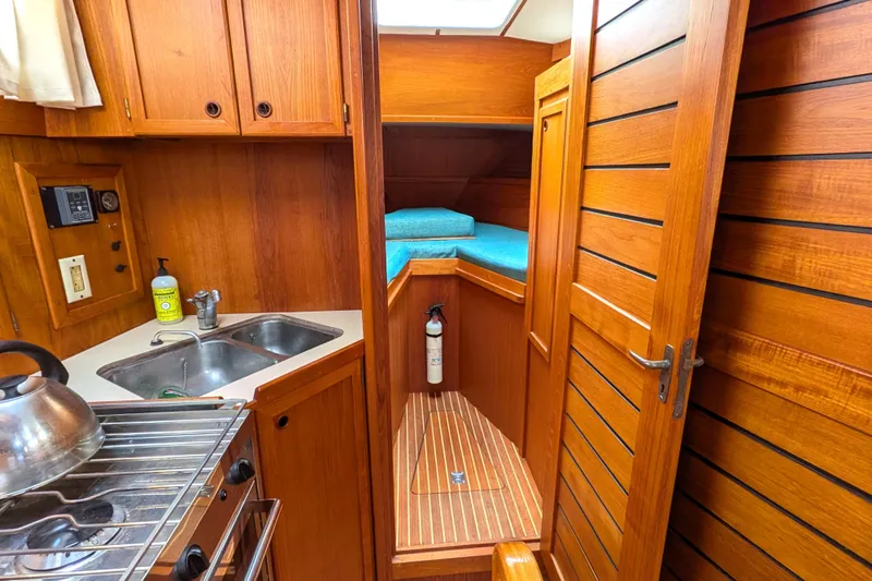Firefly Yacht Photos Pics Interior of 1985 Siltala Nauticat 44 yacht with wooden cabinetry and compact kitchen.