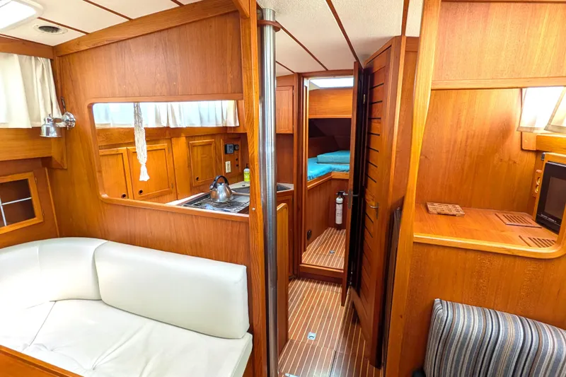 Firefly Yacht Photos Pics Interior of 1985 Siltala Nauticat 44 yacht with wood finish and cozy seating area.