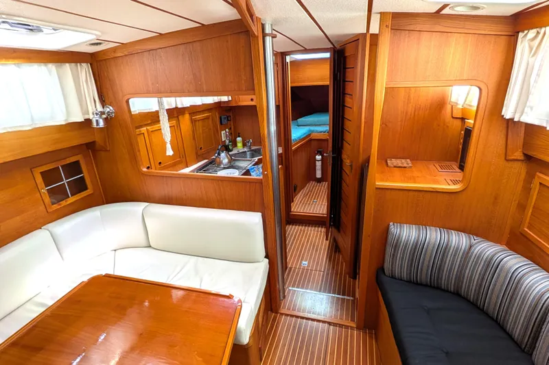 Firefly Yacht Photos Pics Interior of 1985 Siltala Nauticat 44 yacht with wood paneling and cozy seating area.