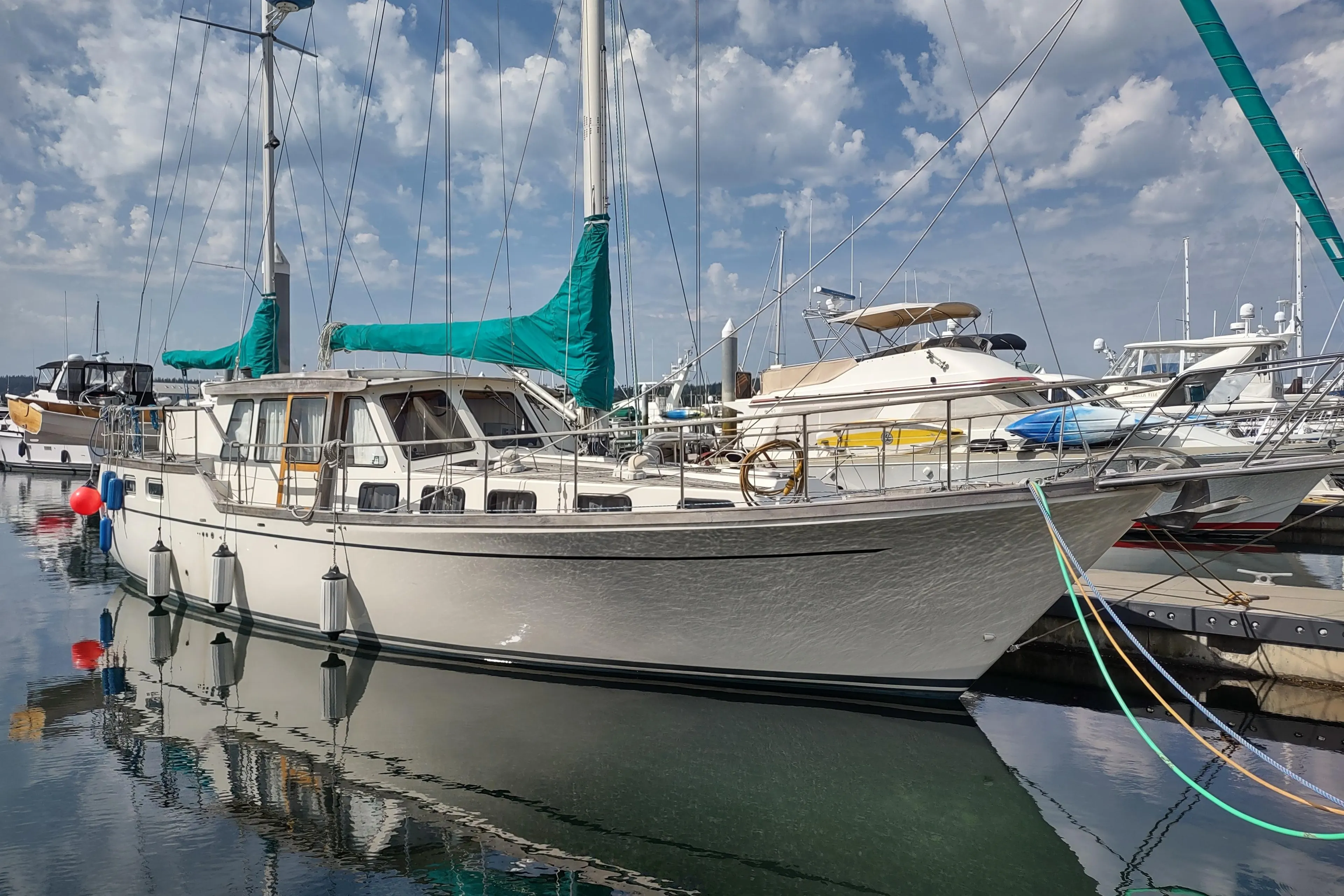 1985 Siltala Nauticat 44 sailboat docked in a marina under a cloudy sky.