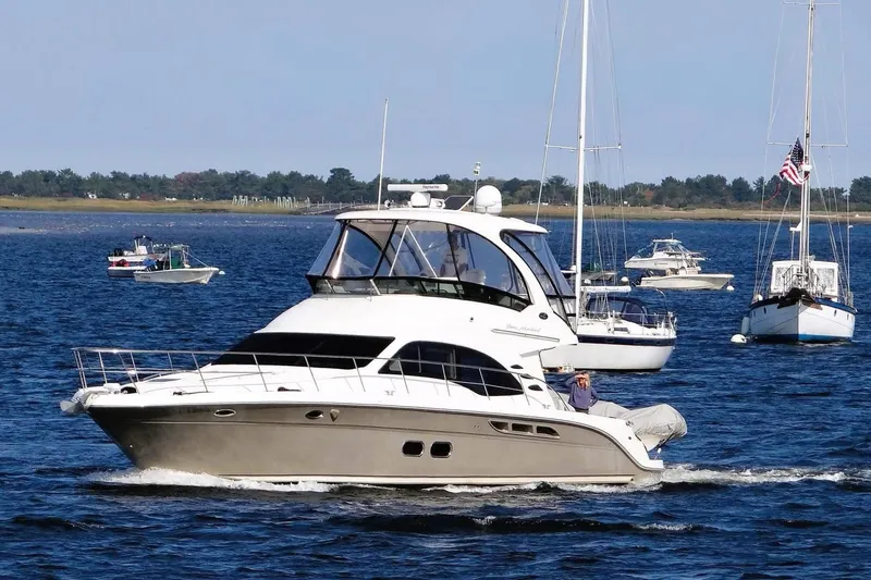 Knot Available Yacht Photos Pics 2005 Sea Ray 500 Sedan Bridge yacht cruising on a sunny day with other boats nearby.