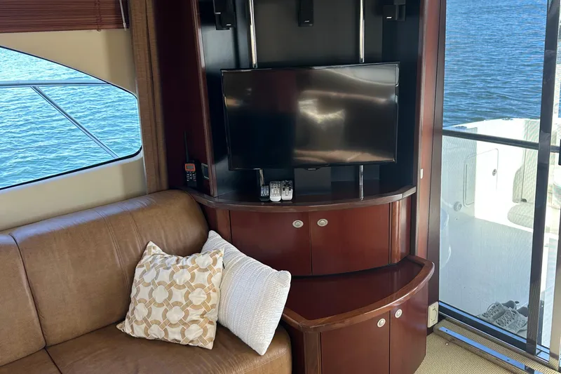 Knot Available Yacht Photos Pics Luxurious 2005 Sea Ray 500 Sedan Bridge interior with TV, sofa, and water view.