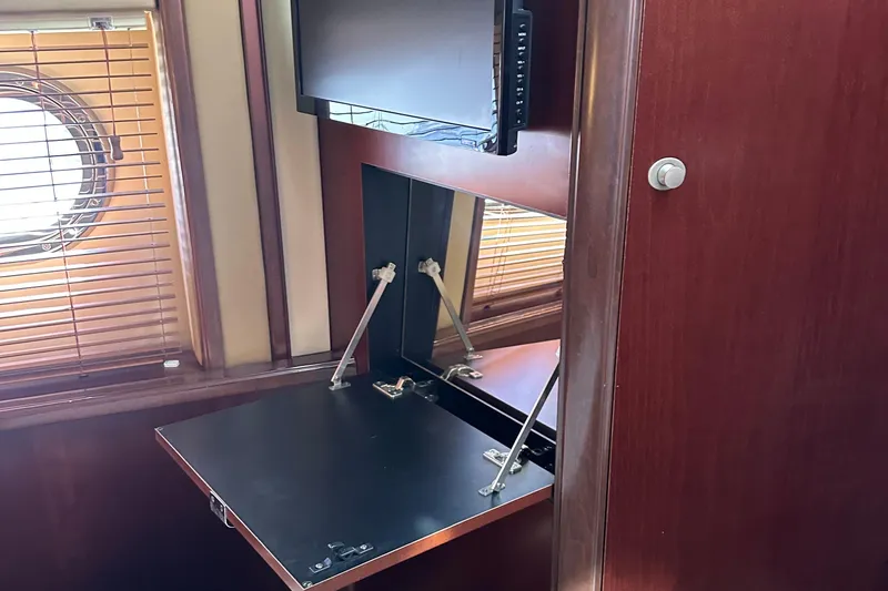 Knot Available Yacht Photos Pics 2005 Sea Ray 500 Sedan Bridge interior with fold-out desk and porthole window.