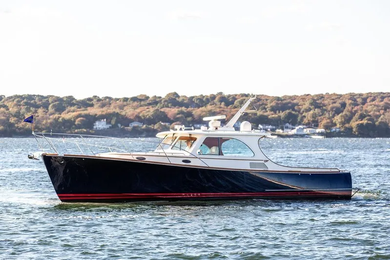 Checkout Time Yacht Photos Pics 2007 Hinckley Talaria 40 yacht cruising on a scenic lake with wooded shoreline.