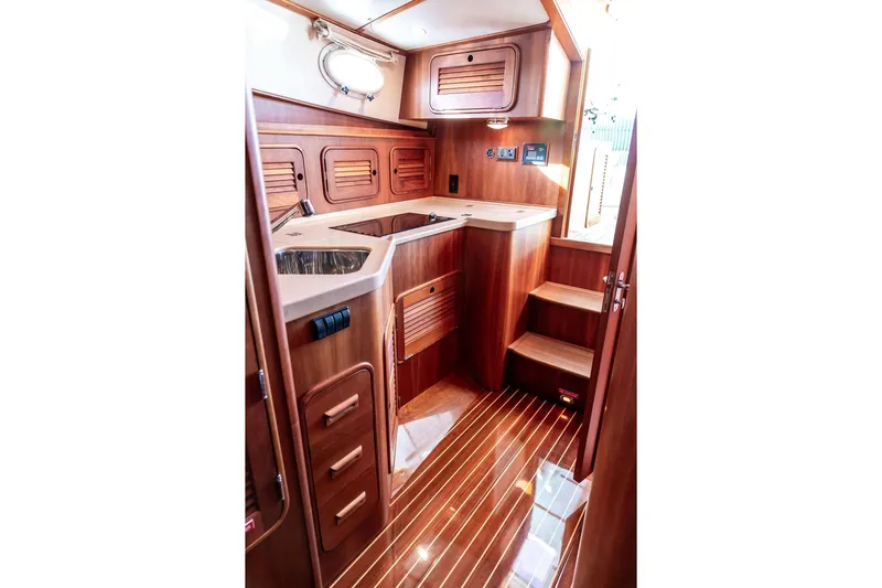 Checkout Time Yacht Photos Pics Luxurious wooden interior of 2007 Hinckley Talaria 40 yacht, featuring a compact kitchen area.