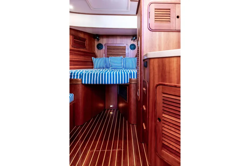 Checkout Time Yacht Photos Pics Interior of 2007 Hinckley Talaria 40 yacht with striped bedding and wooden finishes.