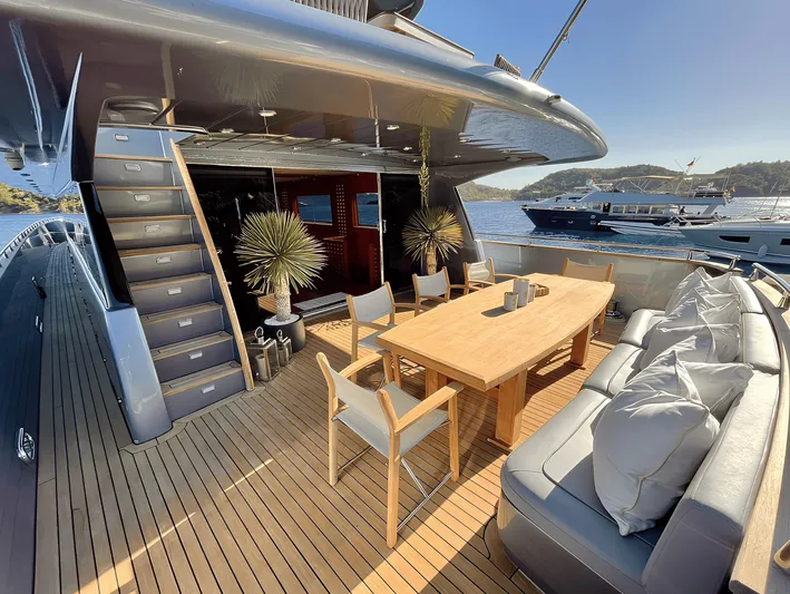  Yacht Photos Pics Luxurious yacht deck with wooden dining table, chairs, and scenic ocean view. Custom model 34, 2008.