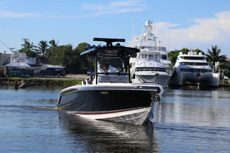  Yacht Photos Pics 2012 Donzi 38 ZF boat cruising in a marina with yachts in the background.