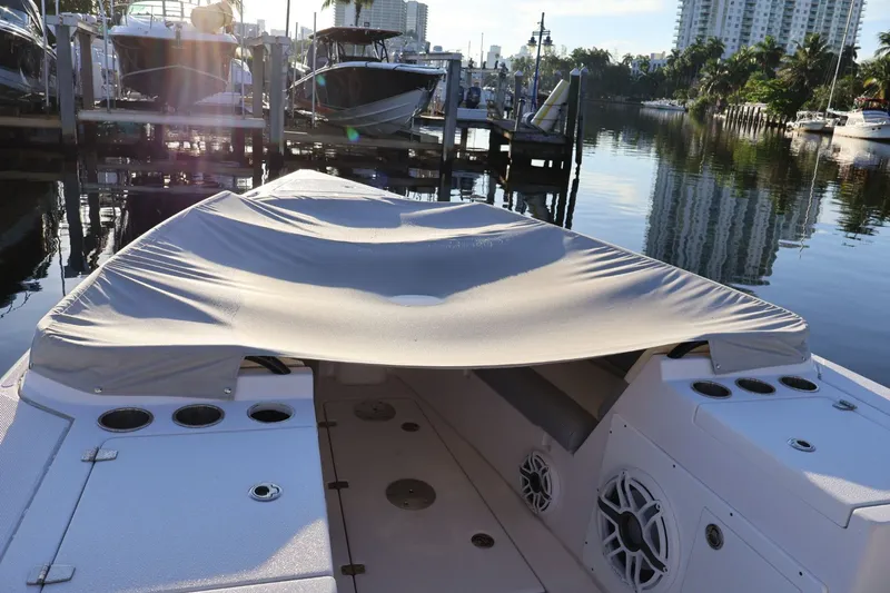  Yacht Photos Pics 2012 Donzi 38 ZF boat docked with cover, surrounded by calm water and other boats.