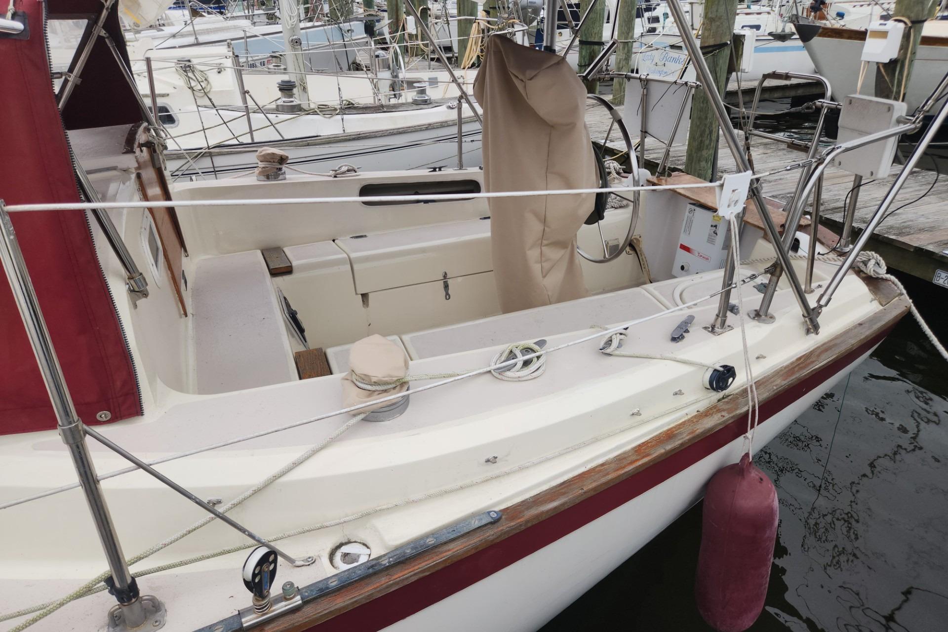 1982 Pearson 323 sailboat docked, featuring a spacious cockpit and maroon accents.