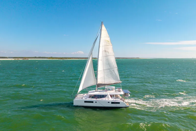 Always Wet Yacht Photos Pics Sailing catamaran Leopard 45, 2021 model, cruising on open sea under clear blue sky.