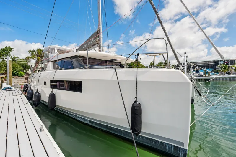 Always Wet Yacht Photos Pics 2021 Leopard 45 catamaran docked at marina under blue sky.