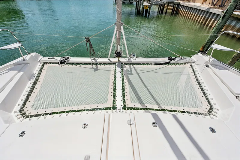 Always Wet Yacht Photos Pics 2021 Leopard 45 catamaran deck with netting over calm water.
