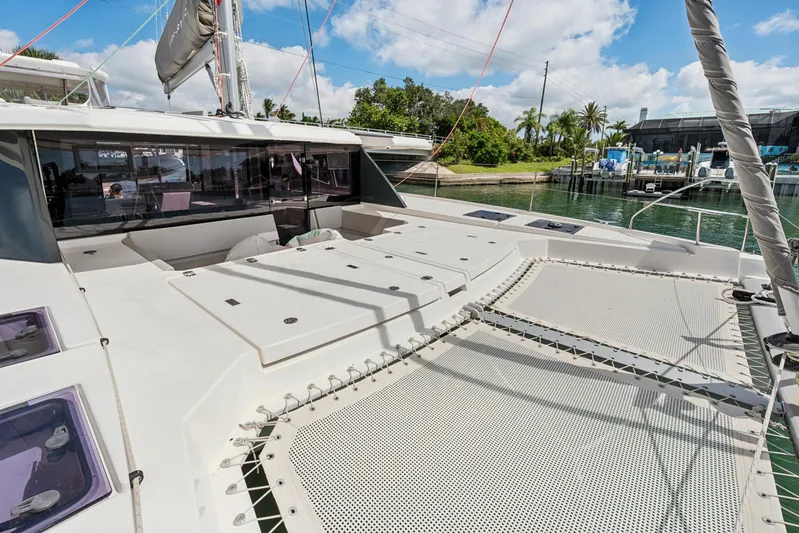 Always Wet Yacht Photos Pics 2021 Leopard 45 catamaran with spacious deck and netting, docked in a scenic marina.