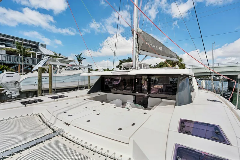 Always Wet Yacht Photos Pics 2021 Leopard 45 catamaran docked, showcasing sleek design and spacious deck under blue skies.
