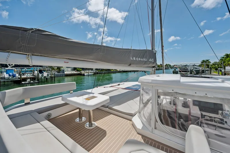 Always Wet Yacht Photos Pics 2021 Leopard 45 catamaran with spacious deck, docked in a sunny marina.