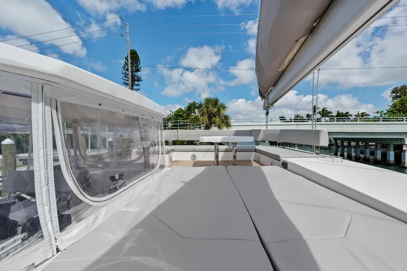 Always Wet Yacht Photos Pics 2021 Leopard 45 yacht deck with seating, clear skies, and bridge in background.