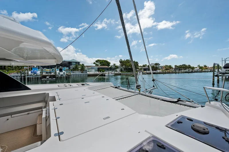 Always Wet Yacht Photos Pics 2021 Leopard 45 catamaran deck with scenic waterfront view and clear blue sky.