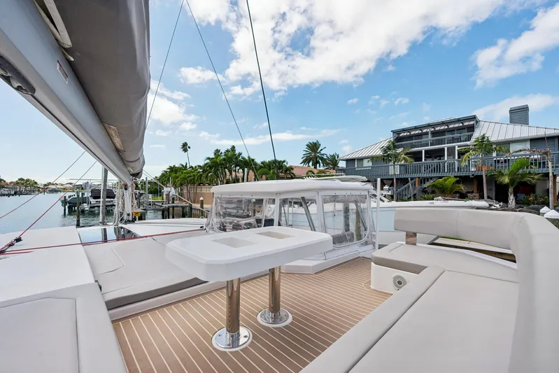 Always Wet Yacht Photos Pics Luxurious 2021 Leopard 45 catamaran with spacious deck, docked near waterfront homes.