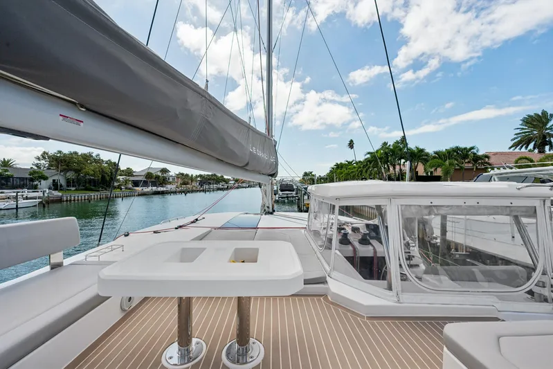Always Wet Yacht Photos Pics 2021 Leopard 45 catamaran deck with seating, table, and marina view.