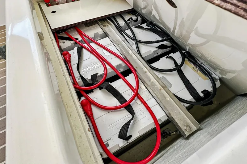 Always Wet Yacht Photos Pics Battery compartment of a 2021 Leopard 45 yacht with red cables and secured batteries.