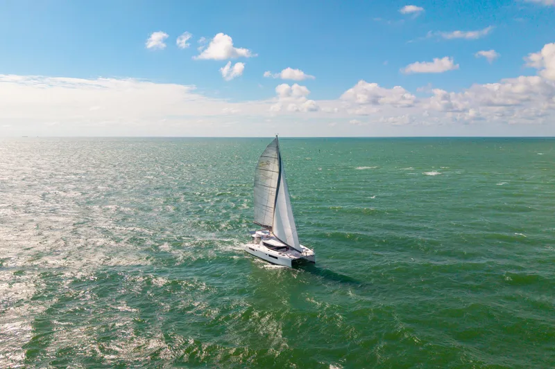 Always Wet Yacht Photos Pics Sailing catamaran Leopard 45, 2021 model, cruising on open sea under clear blue sky.