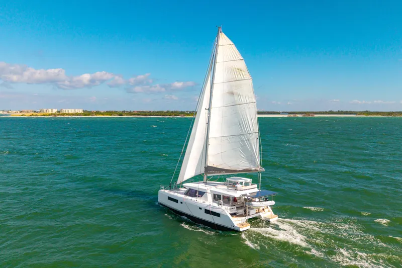Always Wet Yacht Photos Pics Sailing catamaran Leopard 45, 2021 model, cruising on open sea under clear blue sky.