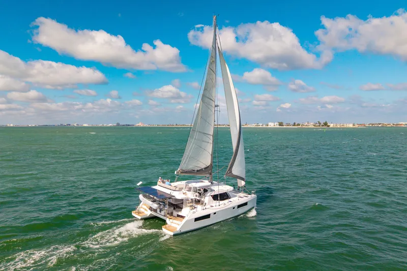 Always Wet Yacht Photos Pics Sailing Leopard 45 catamaran on open sea, 2021 model, under clear blue sky.