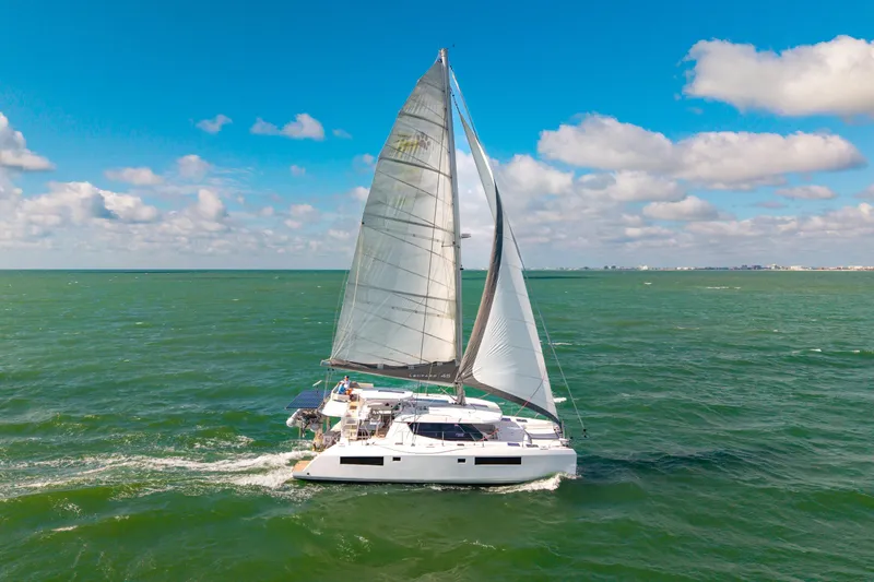 Always Wet Yacht Photos Pics Sailing catamaran Leopard 45, 2021 model, cruising on open sea under clear skies.