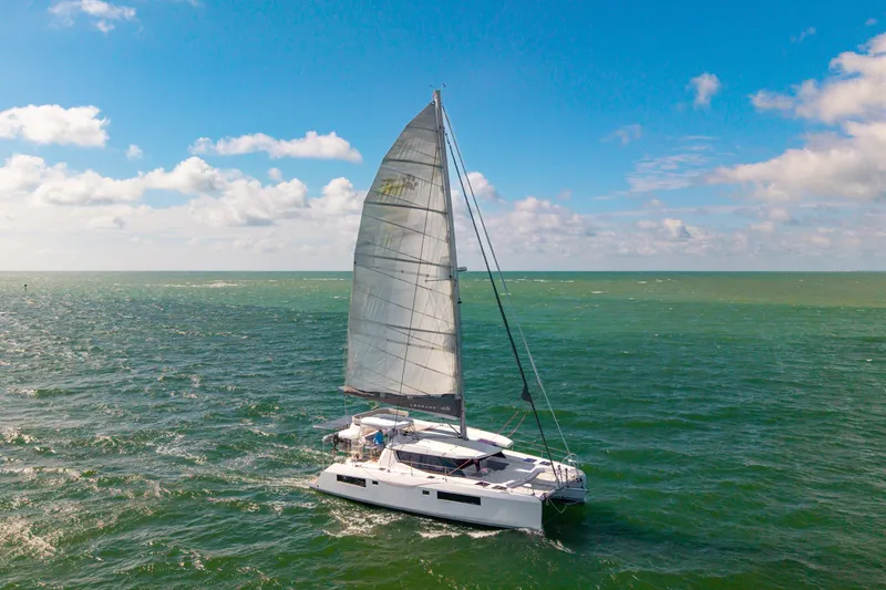 Always Wet Yacht Photos Pics Sailing catamaran Leopard 45, 2021 model, cruising on open sea under clear blue sky.