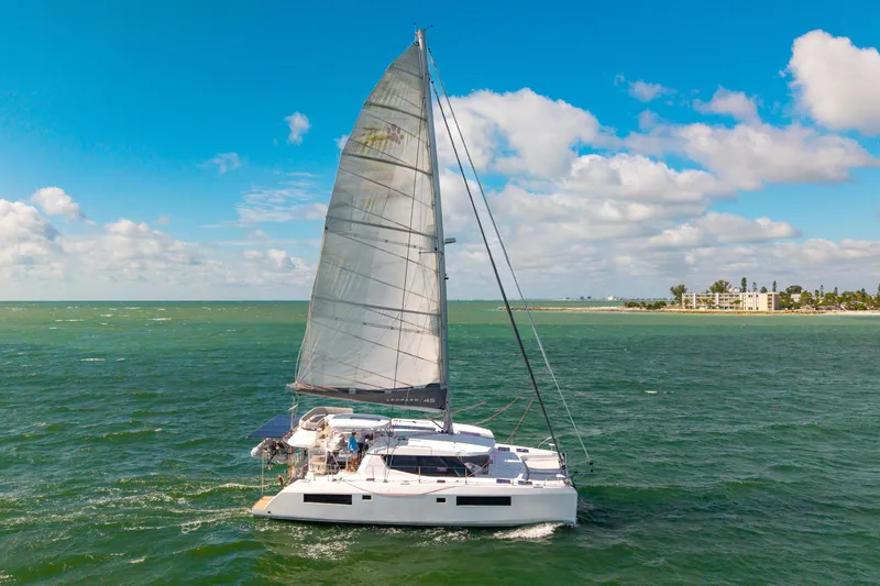 Always Wet Yacht Photos Pics Sailing catamaran Leopard 45, 2021 model, cruising on open sea under clear blue skies.