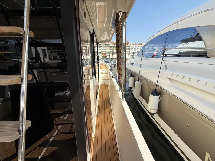 Cassiopee Yacht Photos Pics 2023 Beneteau Swift Trawler 41 Fly, side deck view with marina backdrop.