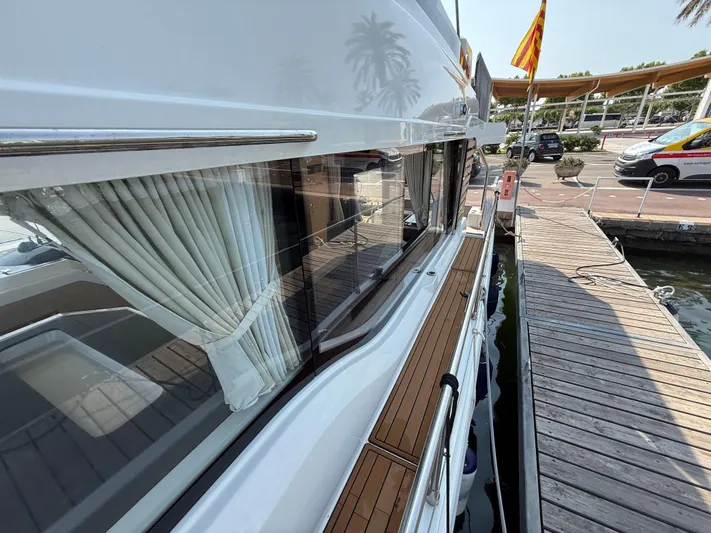 Cassiopee Yacht Photos Pics 2023 Beneteau Swift Trawler 41 Fly docked, showcasing sleek design and elegant window curtains.