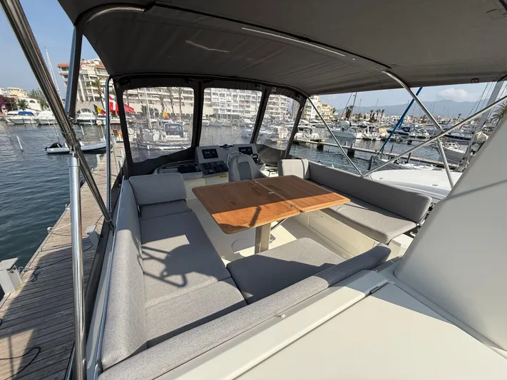 Cassiopee Yacht Photos Pics 2023 Beneteau Swift Trawler 41 Fly, spacious flybridge with seating and table, docked at marina.