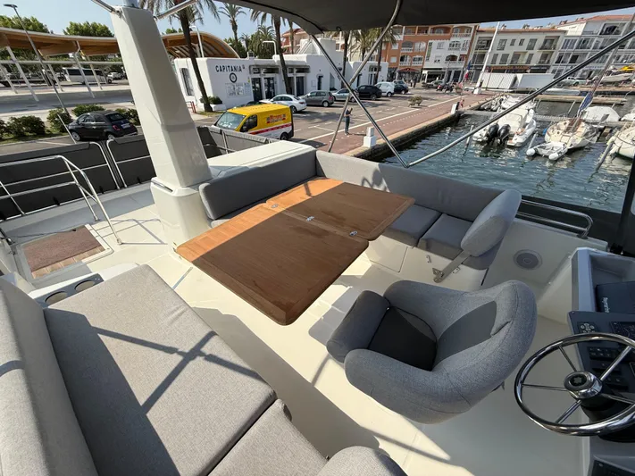 Cassiopee Yacht Photos Pics 2023 Beneteau Swift Trawler 41 Fly, spacious flybridge with seating and table, docked at marina.