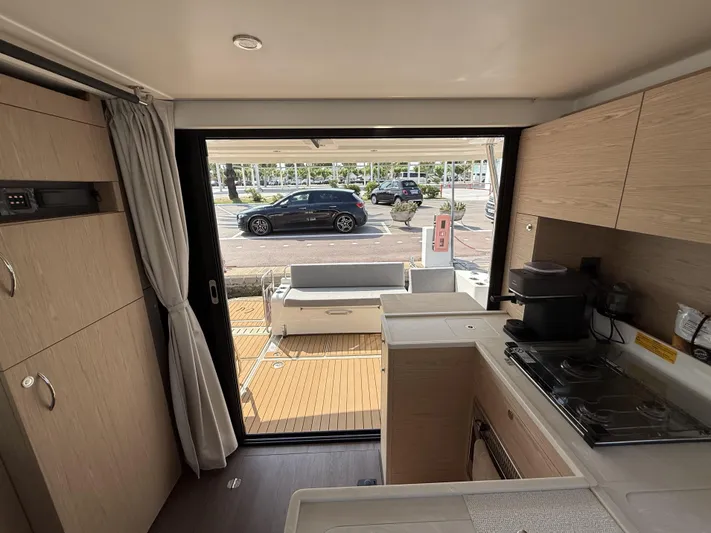 Cassiopee Yacht Photos Pics Interior view of 2023 Beneteau Swift Trawler 41 Fly, featuring modern kitchen and outdoor access.