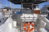 2002 Quer 32 Fish Cuddy boat with seating and life preserver, docked at marina.