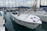 2002 Quer 32 Fish Cuddy boat docked in a marina, surrounded by sailboats.