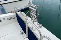 2002 Quer 32 Fish Cuddy boat deck with stainless steel ladder and blue railing.