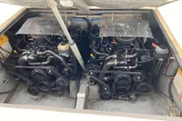 Twin engines in a 2002 Quer 32 Fish Cuddy boat, showcasing mechanical components.