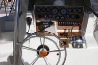 Helm of 2002 Quer 32 Fish Cuddy boat with steering wheel and control panel.