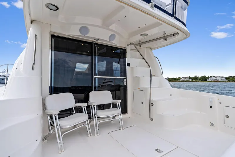 Sea-dels Yacht Photos Pics 2007 Sea Ray 58 Sedan Bridge yacht deck with seating, overlooking serene waters.