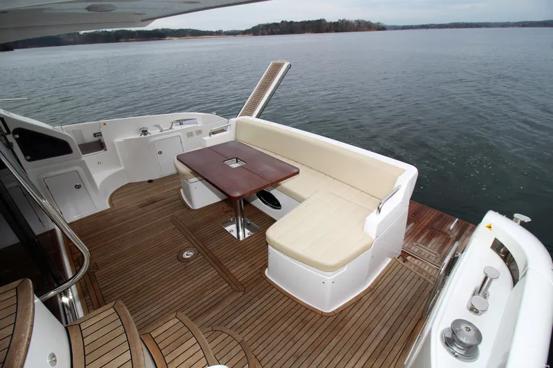Raven Yacht Photos Pics 2014 Azimut 54 Fly Bridge yacht deck with seating and table, overlooking serene water.