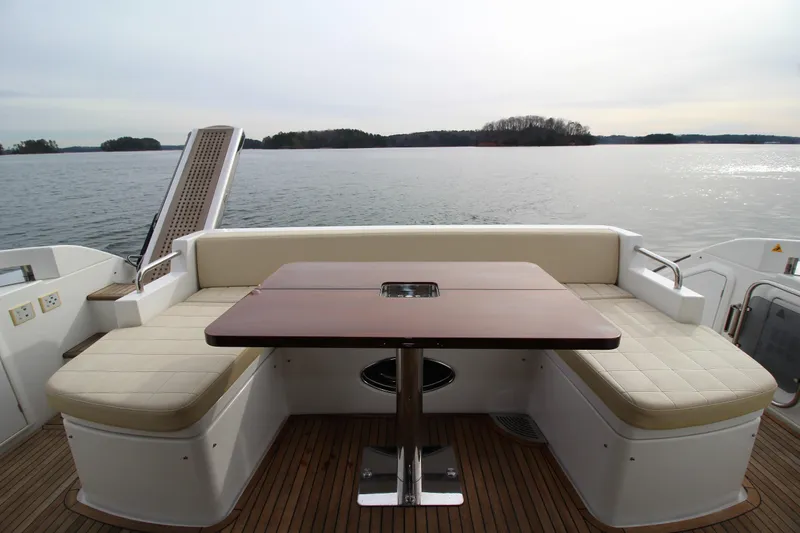 Raven Yacht Photos Pics 2014 Azimut 54 Fly Bridge yacht with elegant outdoor seating and table, overlooking serene waters.