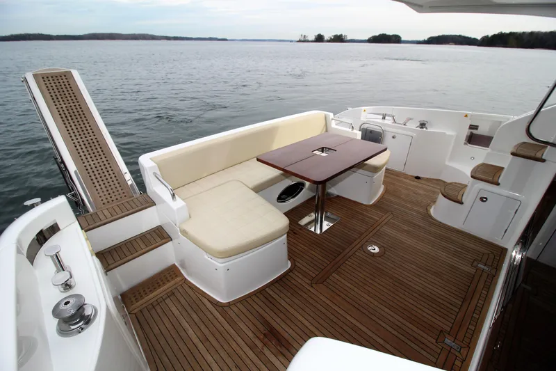 Raven Yacht Photos Pics Luxurious 2014 Azimut 54 Fly Bridge yacht deck with seating and table, overlooking serene waters.
