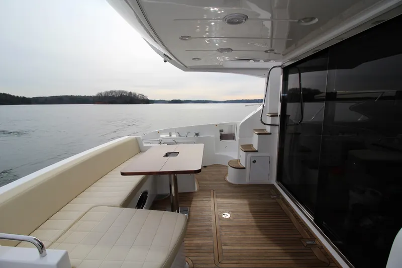 Raven Yacht Photos Pics 2014 Azimut 54 Fly Bridge yacht deck with seating and table, overlooking calm waters.