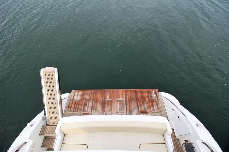 Raven Yacht Photos Pics 2014 Azimut 54 Fly Bridge yacht with wooden deck, overlooking calm water.