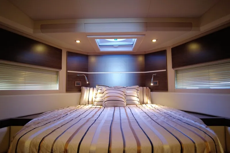 Raven Yacht Photos Pics Luxurious bedroom interior of 2014 Azimut 54 Fly Bridge yacht with striped bedding.